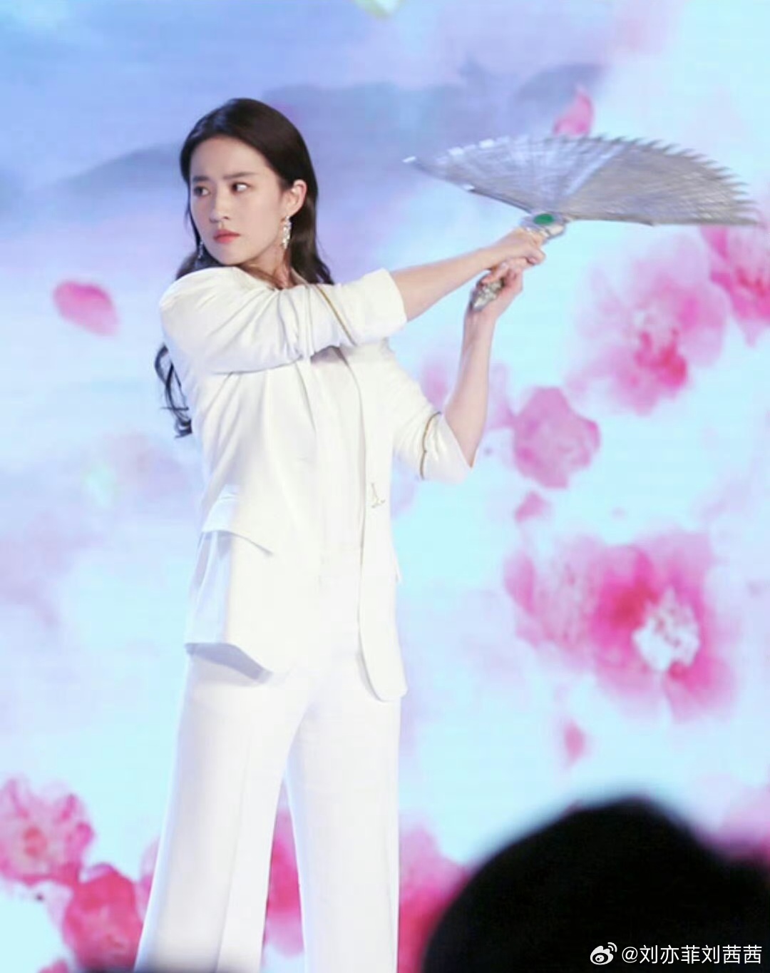 刘亦菲此次活动的核心单品是一身纯白色西装套装，利落的剪裁与垂坠感极佳的面料，完美