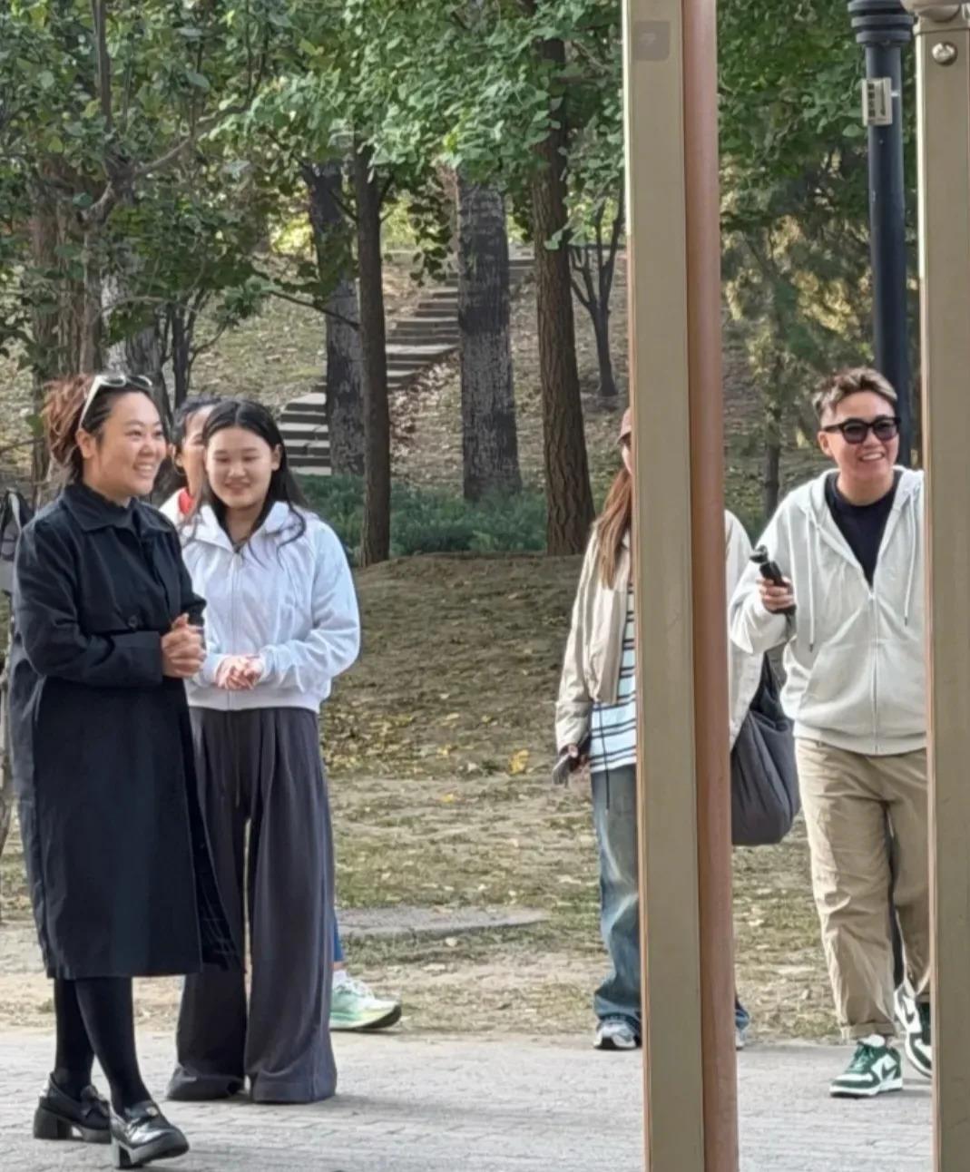 奥运冠军张家齐在北京朝阳公园被偶遇，穿着灰色卫衣慢跑，停下来看大爷吊单杠看得津津