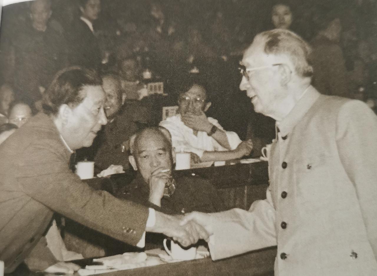 1981年，在一次中央会议上，薄一波同开国中将秦基伟握手，中间是开国中将余秋里。