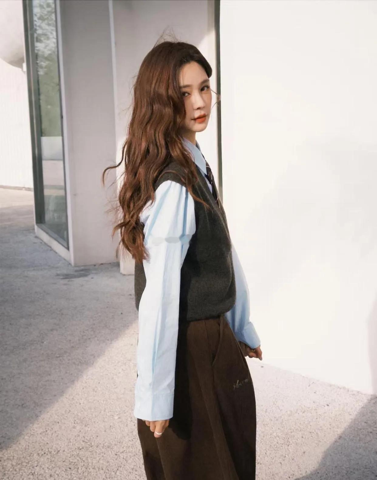 沈梦辰的时尚感愈发惊艳。蓝衬衫打底配V领马甲，层次分明；小棕裤添复古韵味，整套造