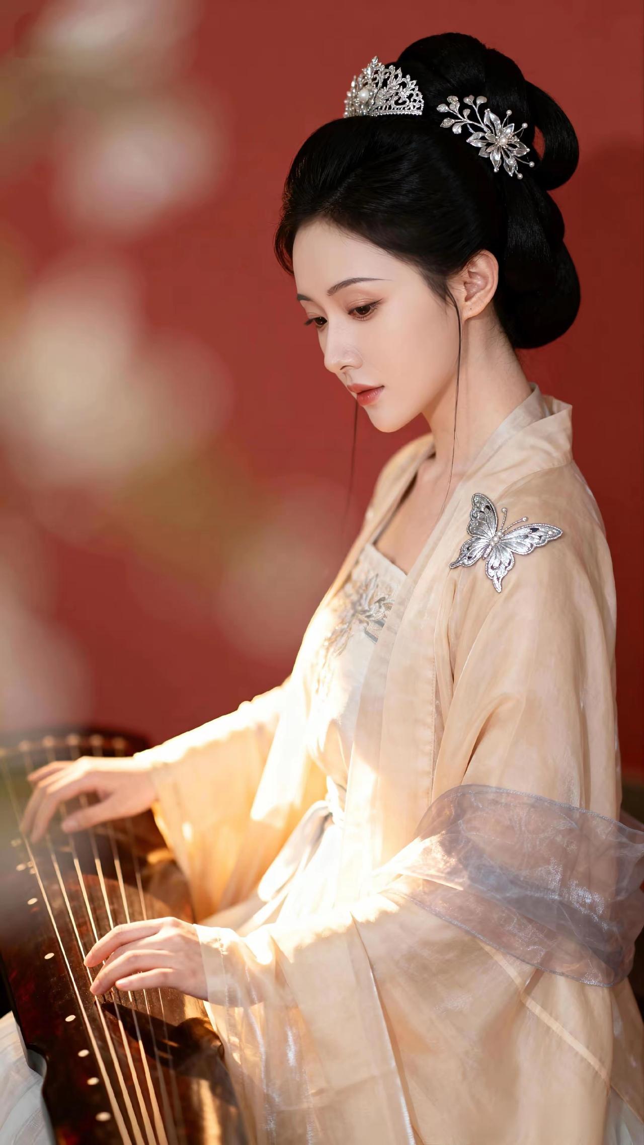 指尖触弦时，琵琶弦颤作流泉，古筝音绕成烟霞。袖间薄纱漫过皓腕，蝴蝶银饰在光里漾开