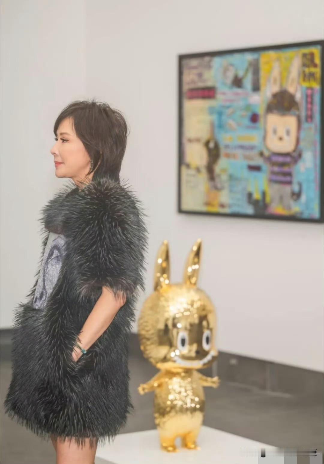 60岁刘嘉玲，依旧是独树一帜的时尚女王。身着黑色毛毛连身短裙现身看展，贵气天