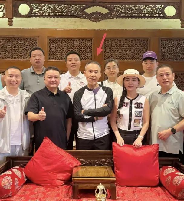 王石和好朋友在一起吃饭，合影时他站在C位，撇着嘴，双手交叉放在胸前，看起来很大佬