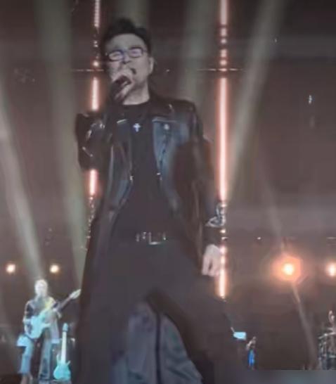 八万人体育馆突然暗下来。荧光棒海还在晃，但声音没了。VJ切画面不是摇滚MV，