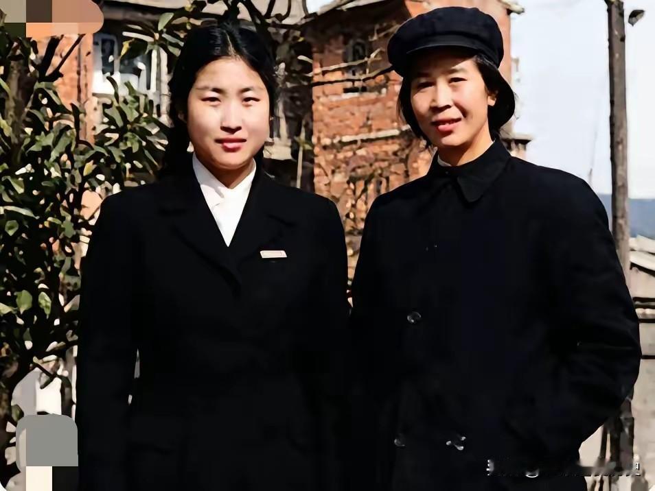 这张老照片定格了贺子珍与女儿李敏的温情时刻。二人身着素净黑衣，立于院落草木间。