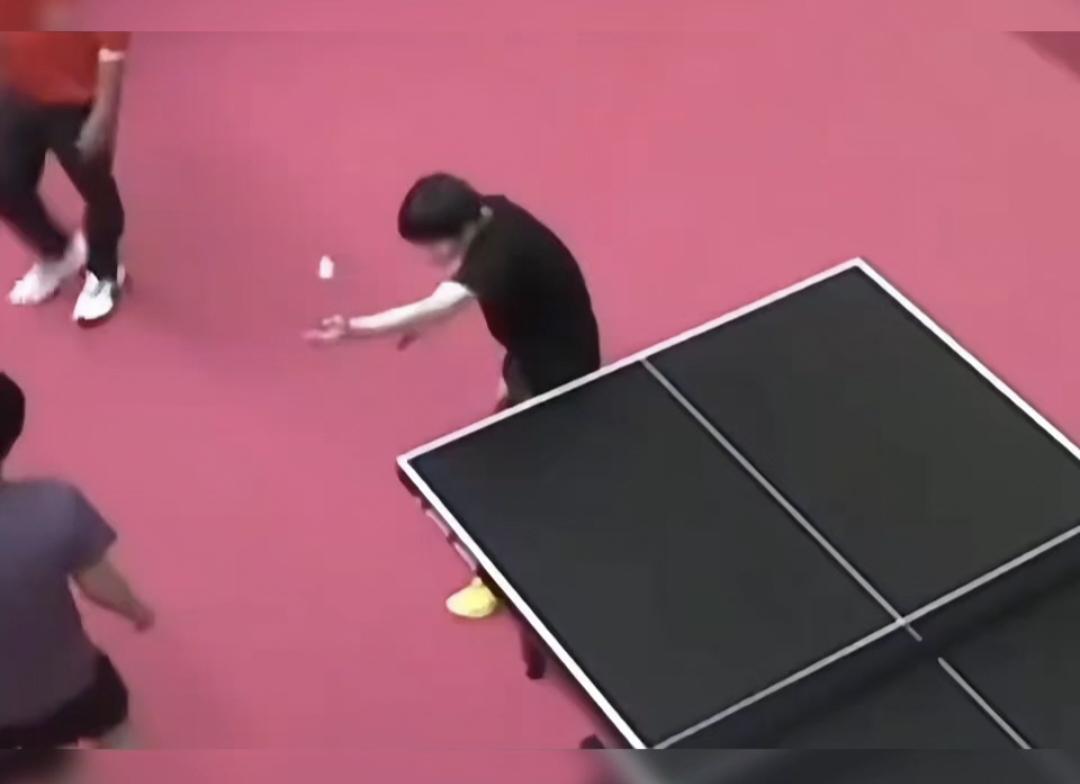 发言人看到莎莎的勾手发球很不标准时，萧指指了指大头说你教教他。大头立马放下手中