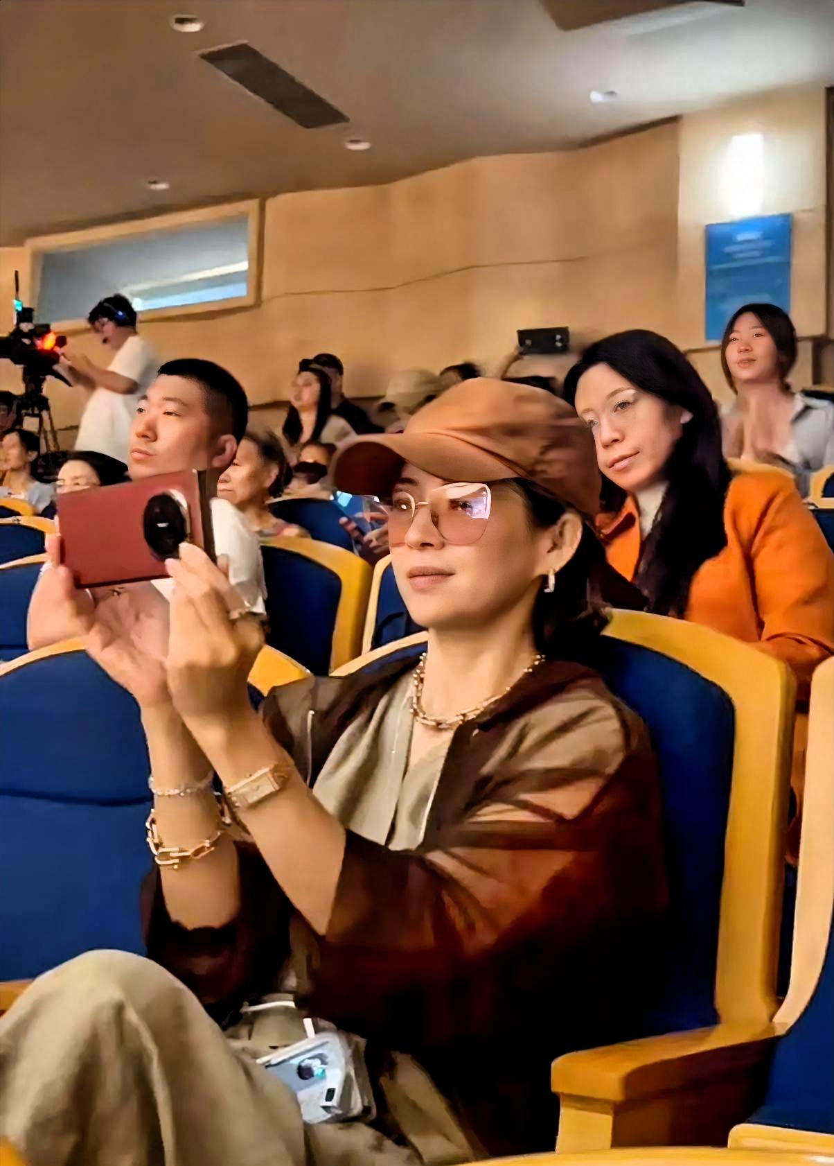 章子怡坐在台下，手机举了整整三首歌。不是媒体镜头对着她的那种举法。是当妈的那