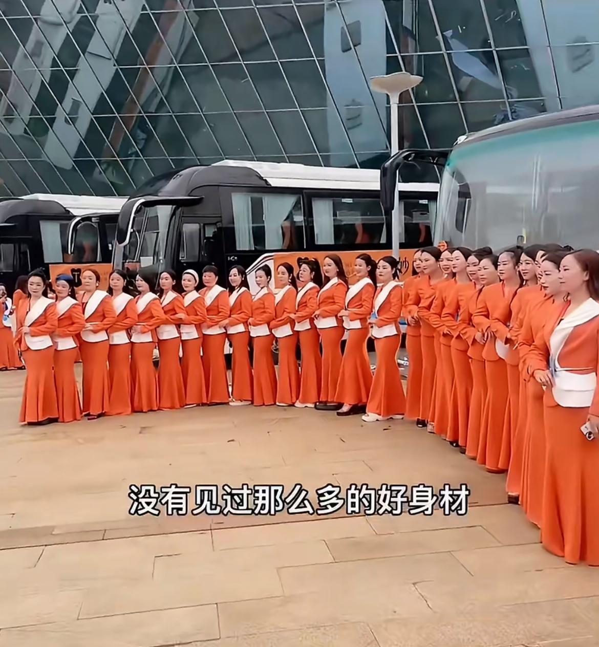 乌泱泱的一群统一着装的中年少女在搞事业，都是精致身材的职业装，橙黄色非常惹眼，据