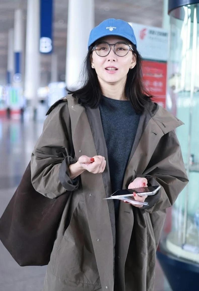 胡静这机场穿搭，减龄又舒服✨卡其色风衣+灰色毛衣+棒球帽，松弛感直接拉满！