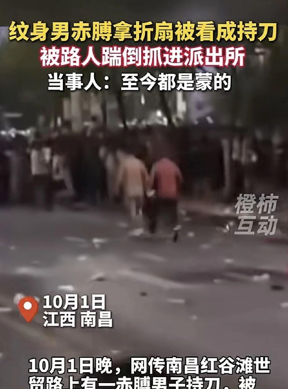 纹身男子光着上身，手持一把折叠扇子逛街，被路人误认成持刀。这时，一名红衣男子从后