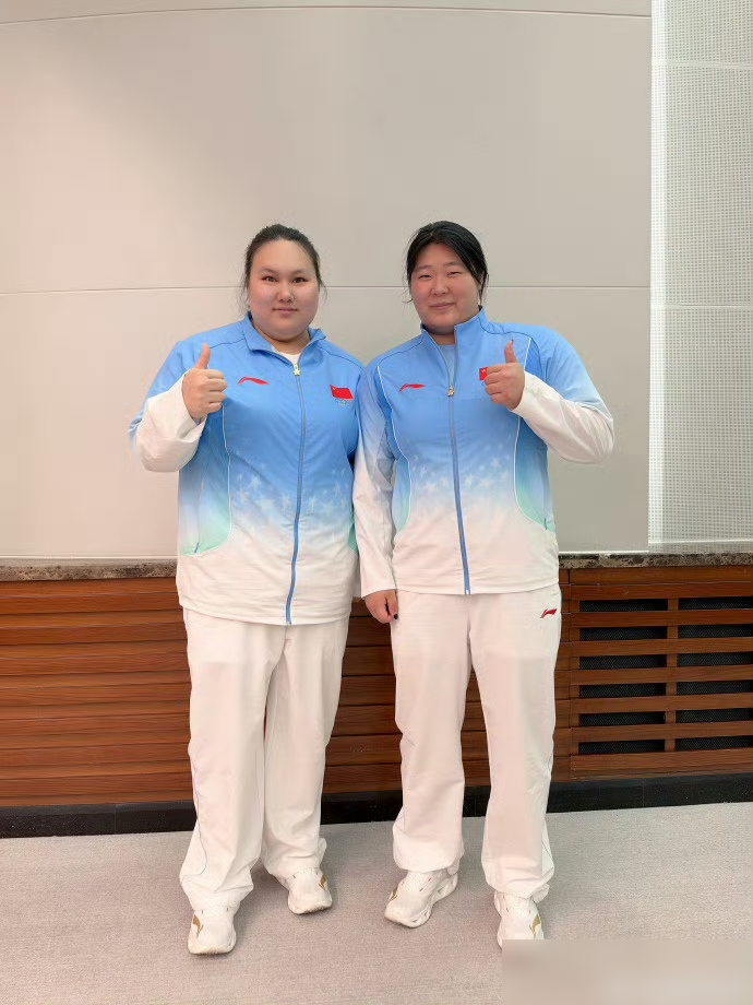 李雯雯举着140公斤抓举成绩，随手发了个合影，旁边站着的姑娘更狠。这人叫严子怡，扔标枪的。名古屋亚运