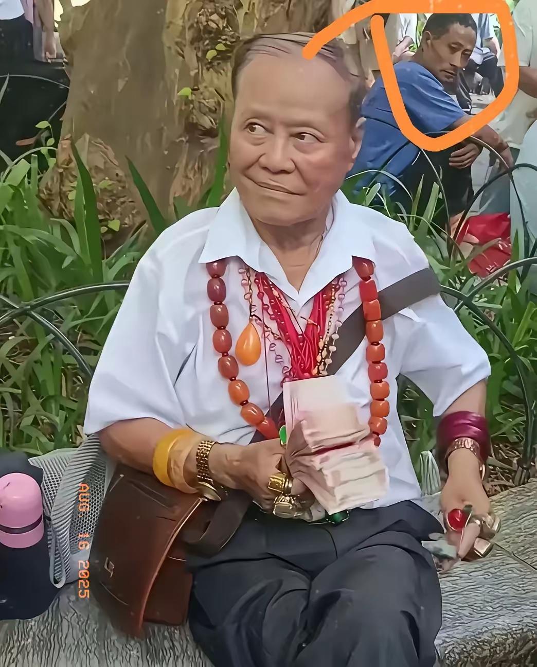 这张照片，你看到了什么？大家仔细瞧一瞧，前面坐着的大爷手里拿着一打厚厚的票子，