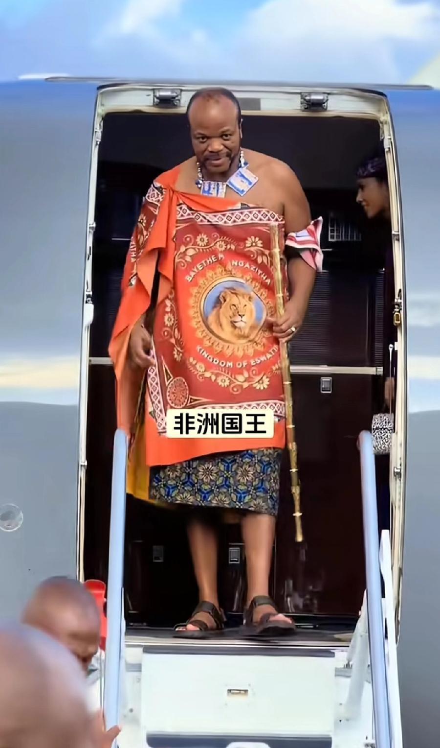 斯威士兰老国王与他的私人飞机，先看看本人造型，可拉风吧，脚踩拖鞋，身上披一张花床