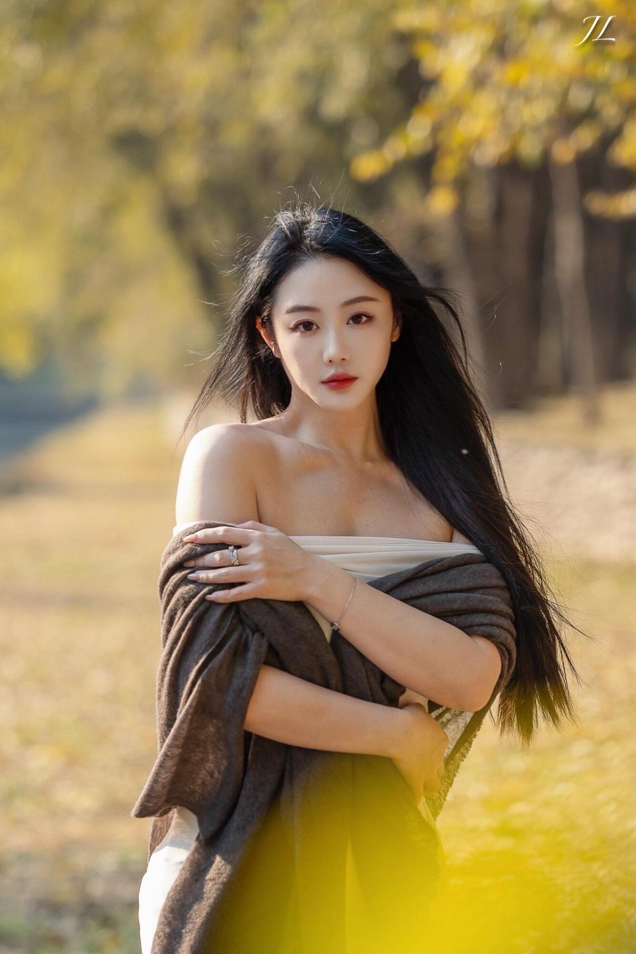 《秋日氛围感摄影：当白裙遇见鎏金树叶》当暖黄的秋叶垂落肩头，白裙与暮色棕披肩