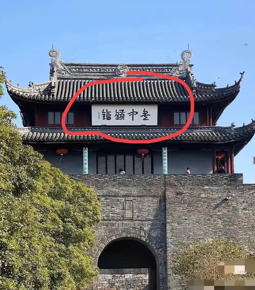 图中城楼牌匾上的四个字估计活有几个人认识！城门上的四个字的行草书，反正我只认出了