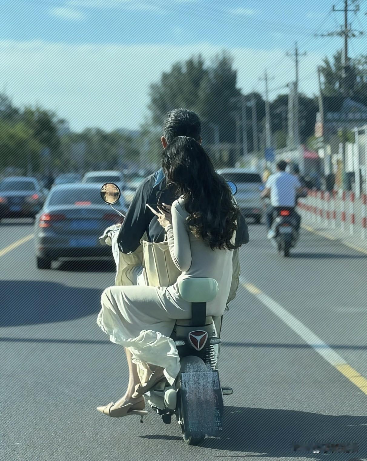 美女的身材真是摄人心魂，但我只想提醒你一句：穿着这样的长裙坐电动车是非常危险的事
