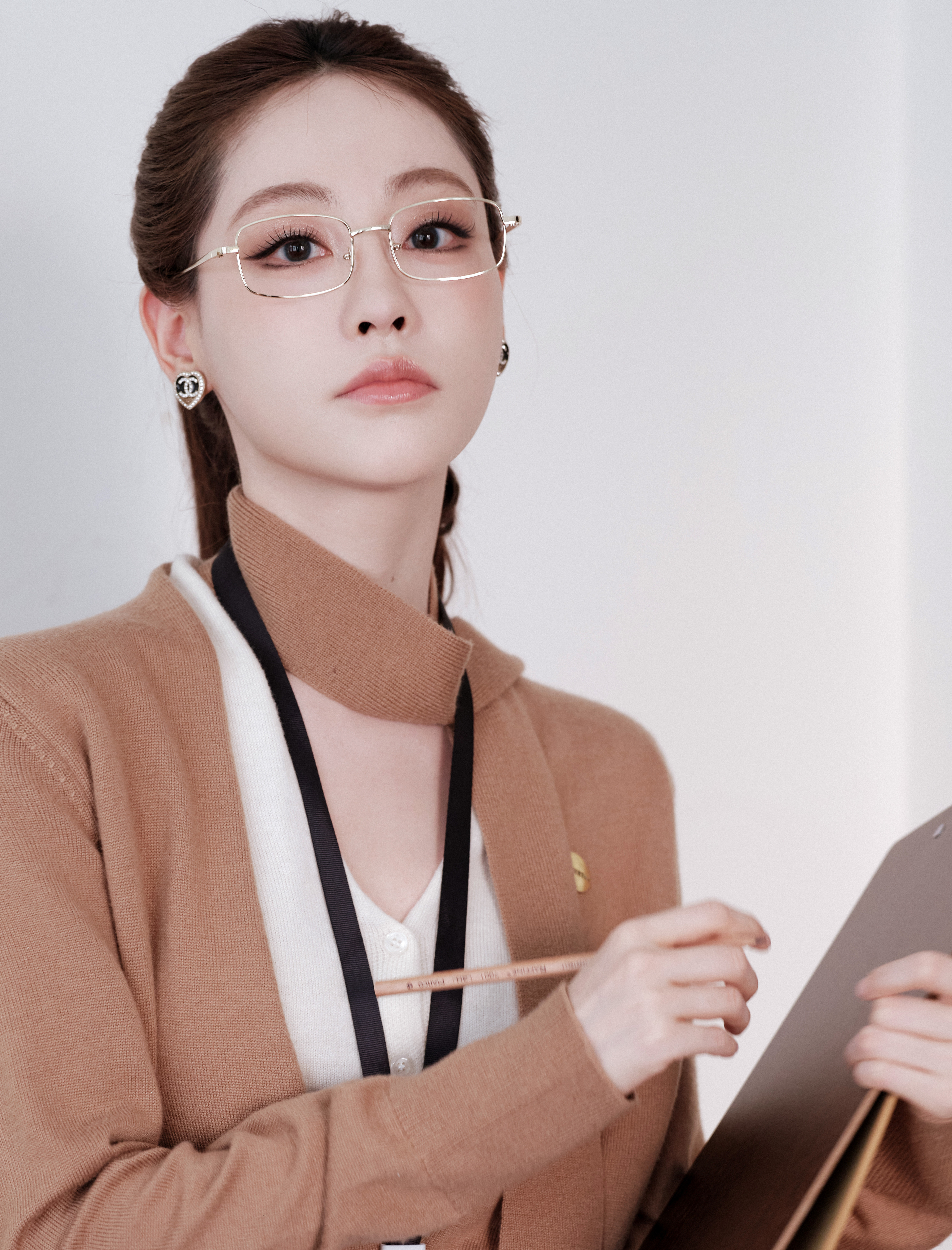 祝绪丹驼色针织裹挟复古肌理，干练马尾挑动职场韵律。