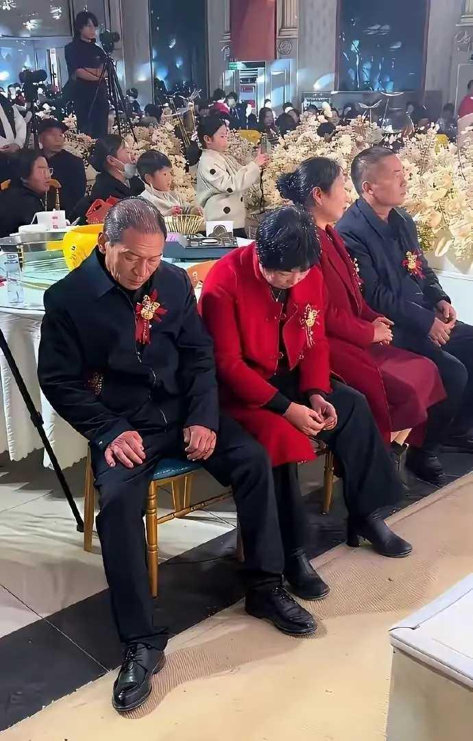 这两对亲家，不用说，垂头的必定是新郎父母，抬头的是新娘父母。儿女婚礼，两亲家也