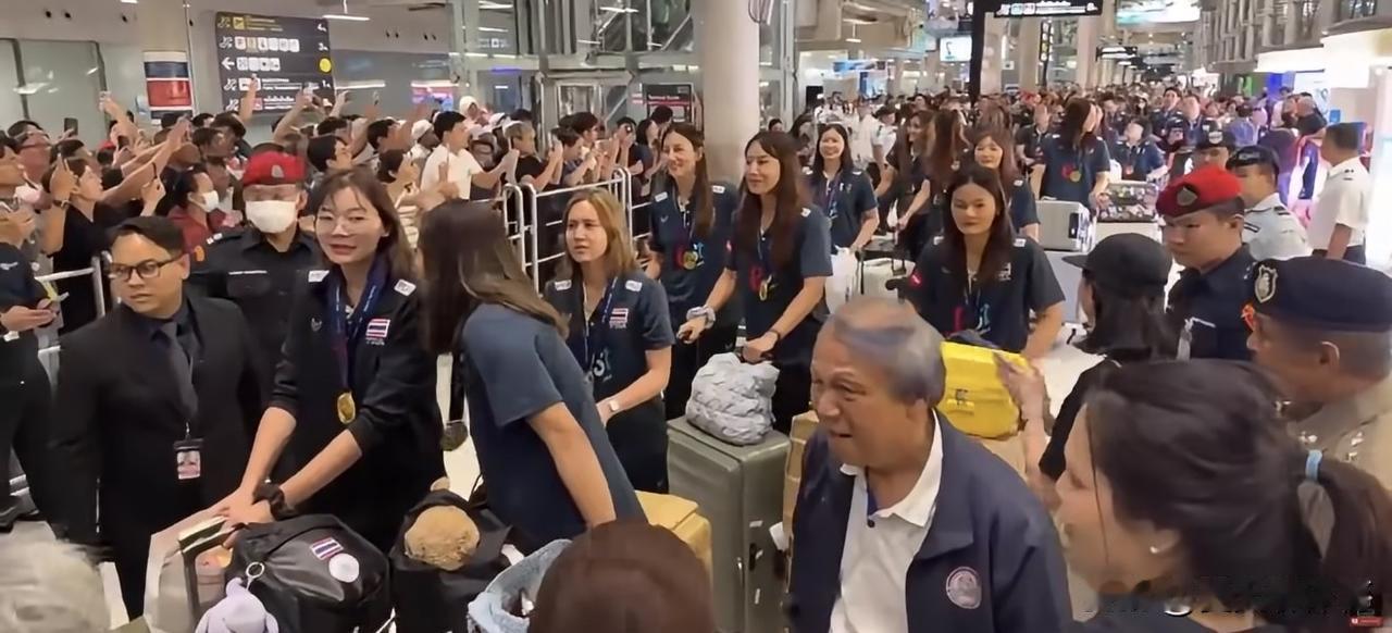 泰国女排载誉回国，机场人山人海，锣鼓喧鸣！主教练加提蓬拿着冠军奖杯，供球迷们观看