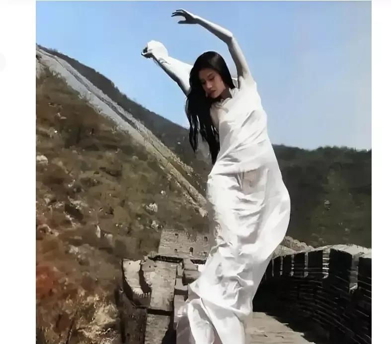 年轻时候的舞蹈家杨丽萍在长城游览时留下的倩影。年轻时的杨丽萍气质优雅，活泼灵动