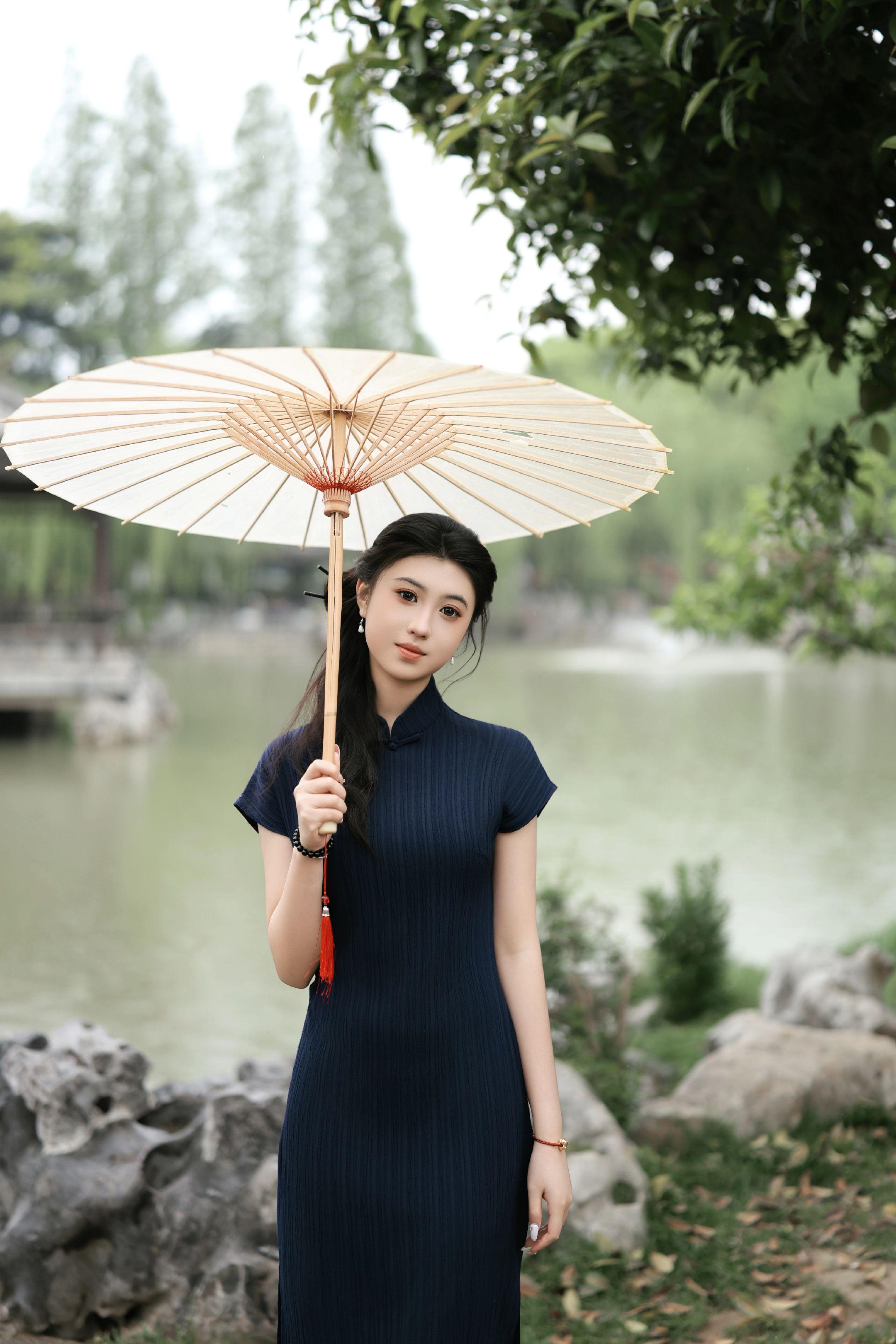 一袭藏蓝，把江南的暮色和温柔都穿在了身上。一袭藏蓝暗纹旗袍，像把江南的...