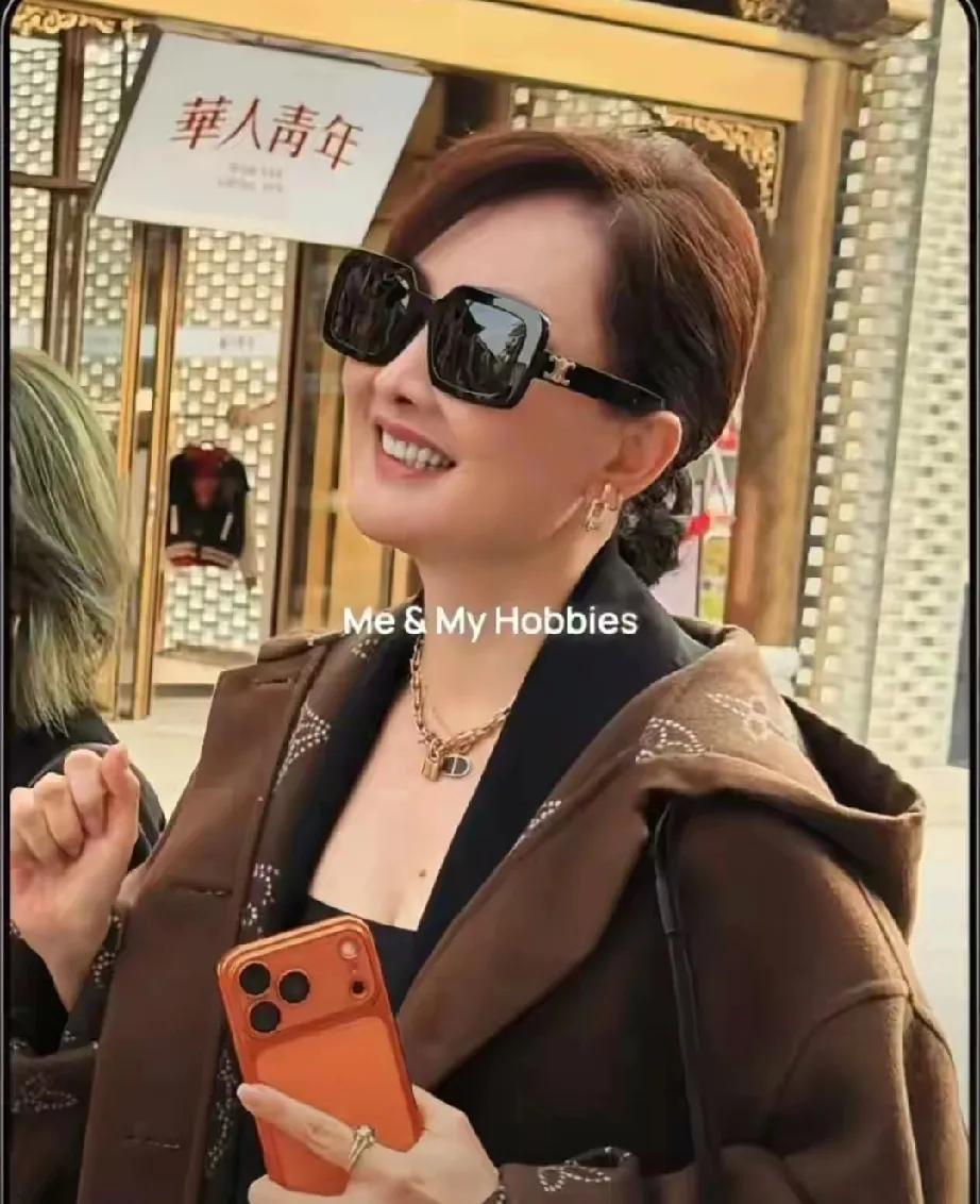 53岁牛莉这是偷偷开了“冻龄挂”吧！寒冬街头，别人裹成粽子，她短裙配长靴，白皙大