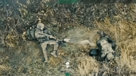 2名受伤的俄军士兵被困在了战壕里，其中1人发现乌军无人机飞来，想举枪拦截，但无奈