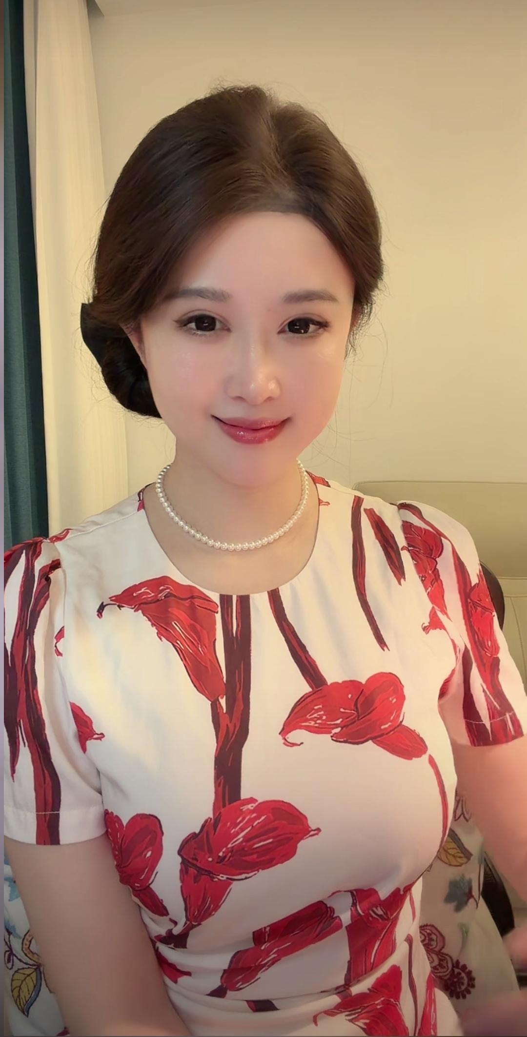 云鬓轻挽配珠链，眉眼含春笑靥甜。红花开衫衬白肤，玉盘珠落美婵娟。
