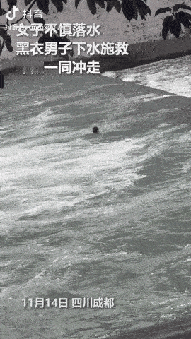 四川成都，一女子在河边游玩时，不慎跌入水中。此时，一位黑衣男子路过，立刻纵身跳入
