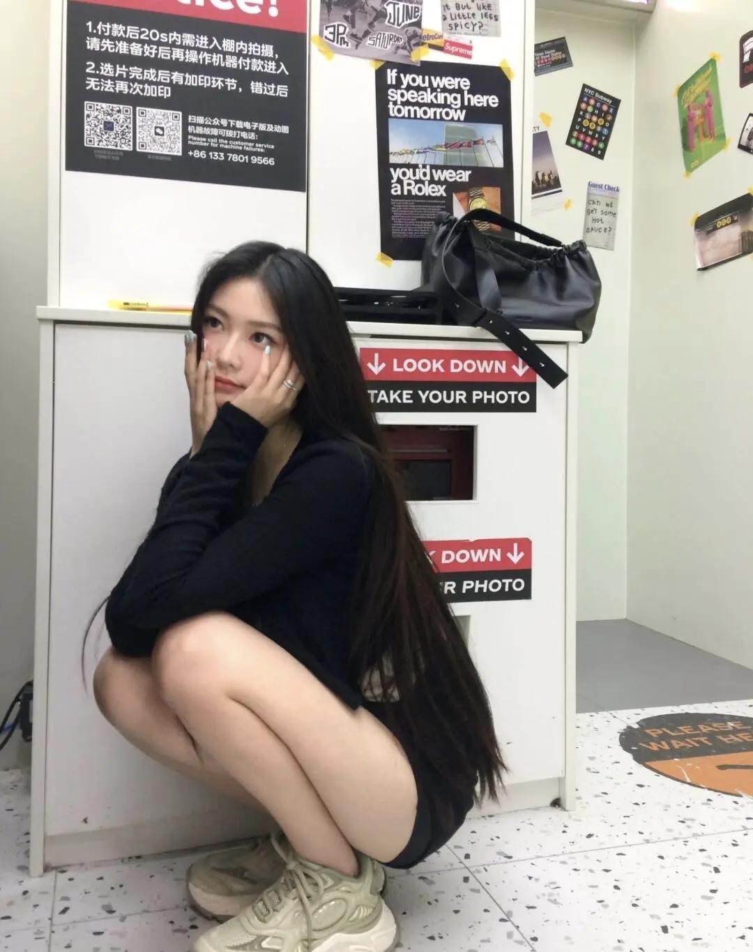 在拍立得机器旁定格的随性瞬间，全黑穿搭揉进几分甜妹的娇憨，让日常的小美好在镜头边