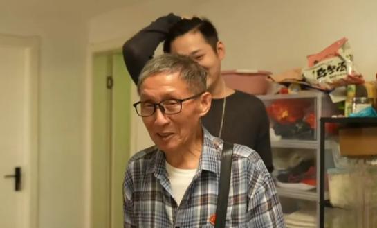 1998年，杭州火车站一男孩正在捡桶里的食物吃，突然，一中年男子走到他身后，俯下