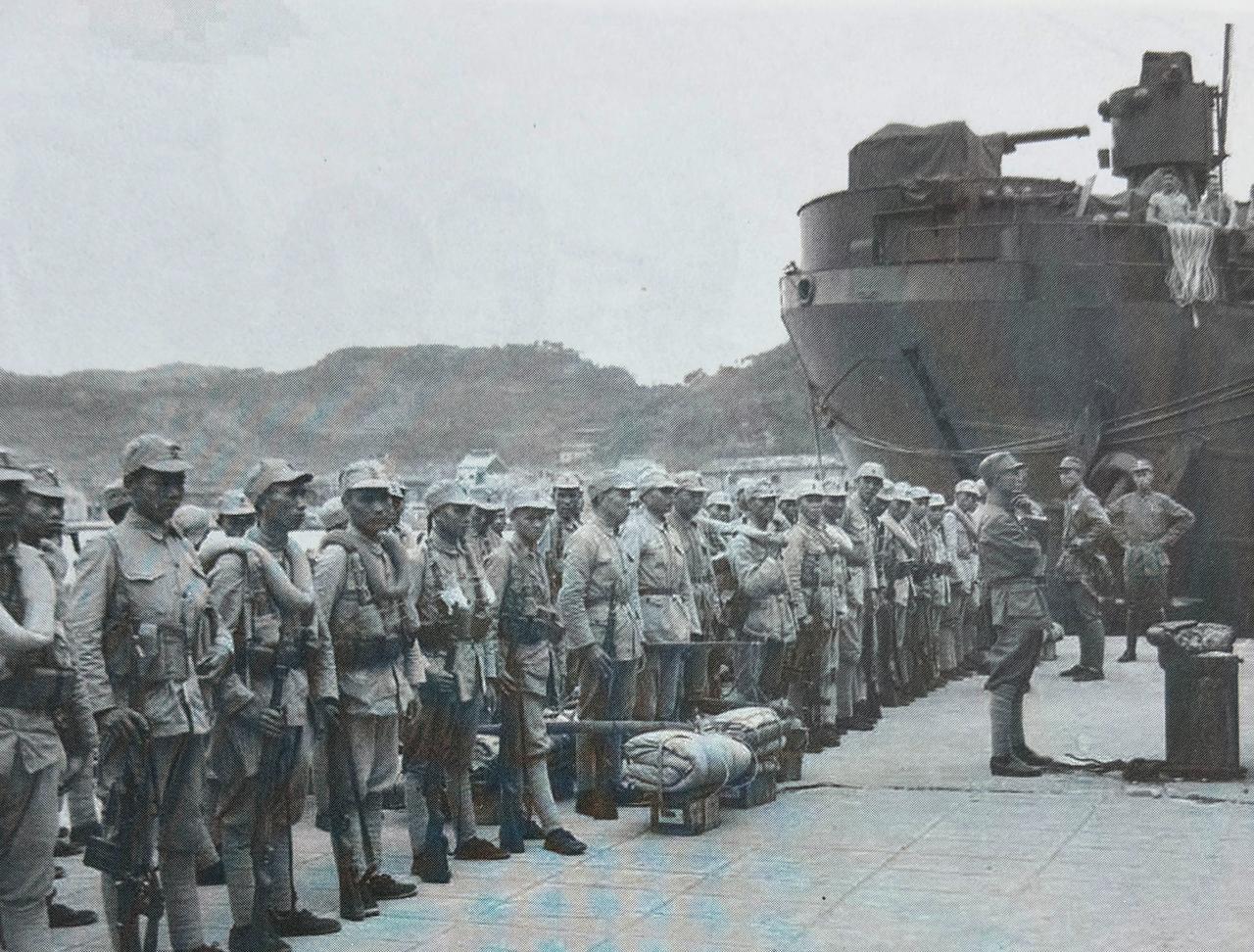 1945年10月17日国民党军第70军士兵乘坐美国登陆舰在基隆港下船后于码头排队