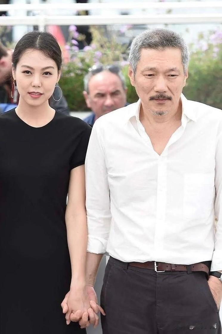 金敏喜和导演洪尚秀，带着孩子参加发布会，他们在台上坐着，孩子就躺在台下的婴儿车里