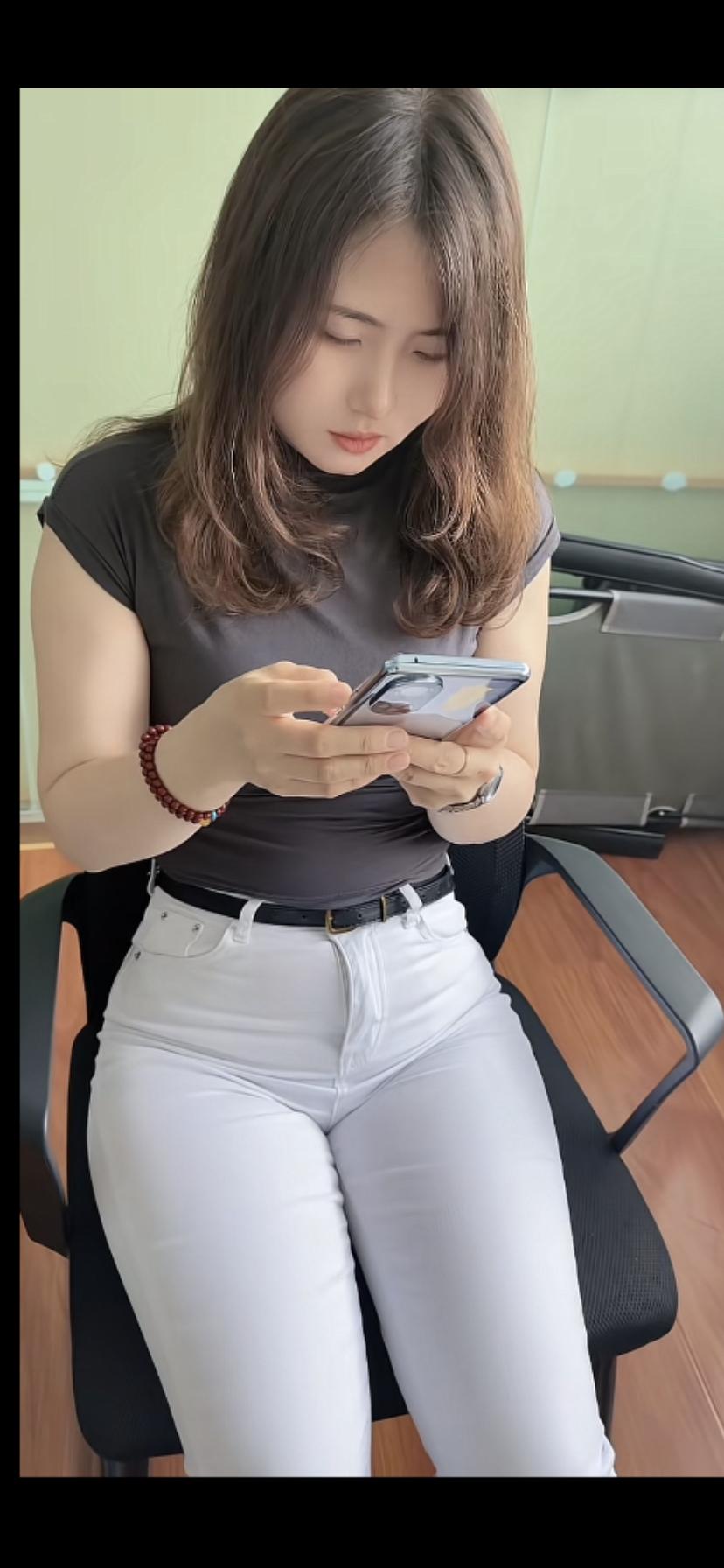 这姑娘正低头看着手机呢。