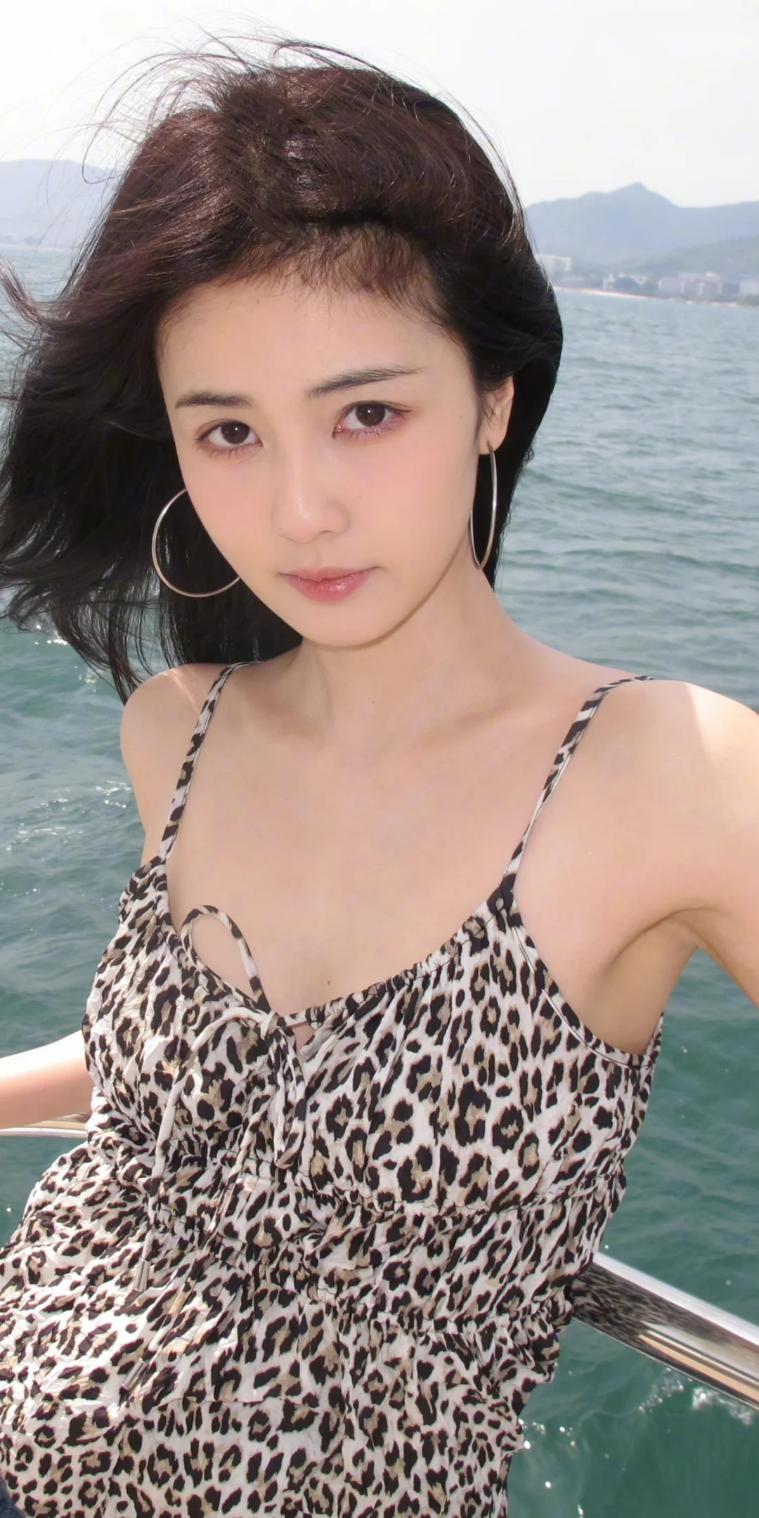 白鹿穿豹纹吊带配牛仔短裤，搭大圈耳环，在海边展现出优雅时尚气质，尽显温婉美丽动人