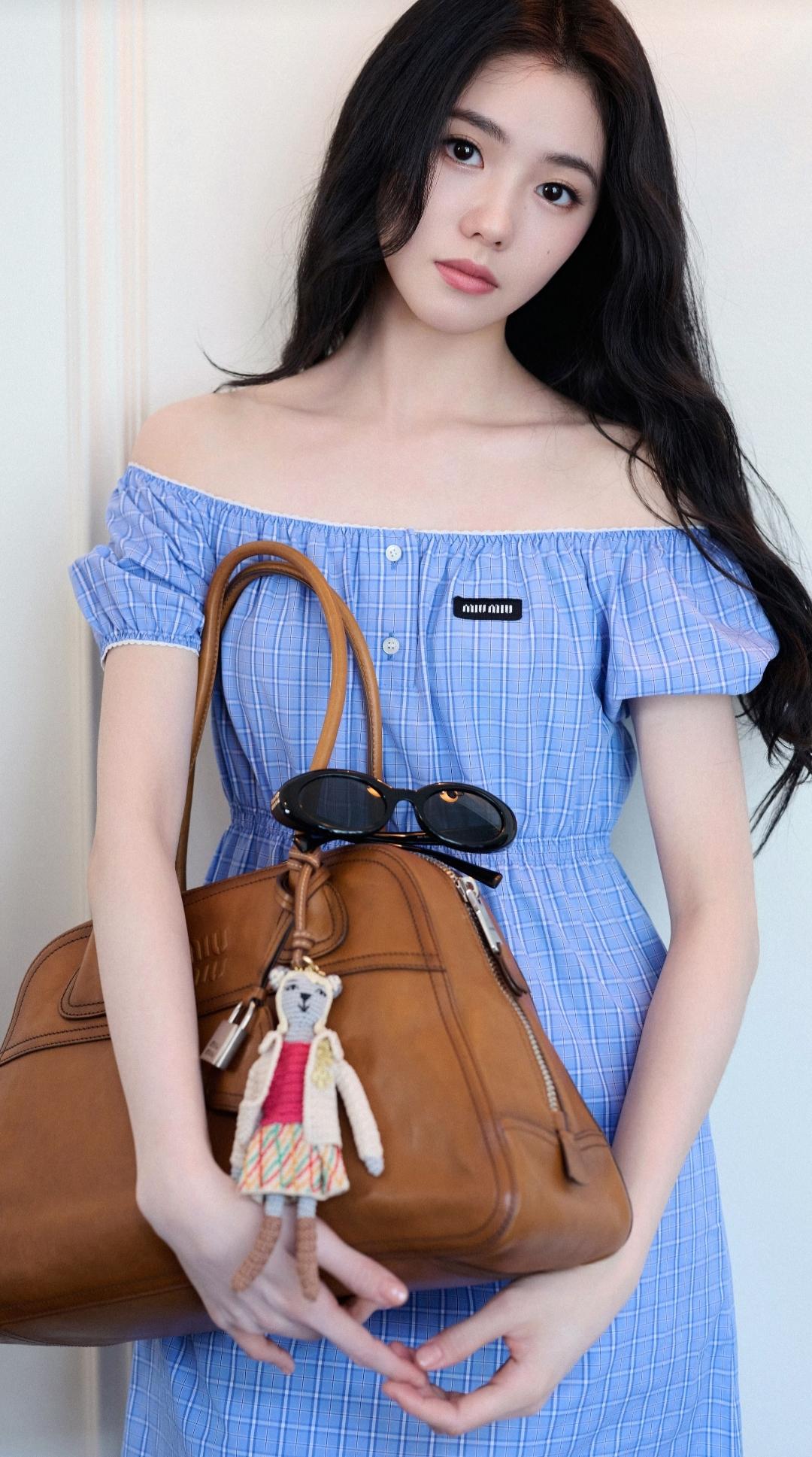 刘浩存更新动态并晒出清纯美照，身着蓝白格子的露肩连衣裙，长发披肩，双腿交叠，脚上