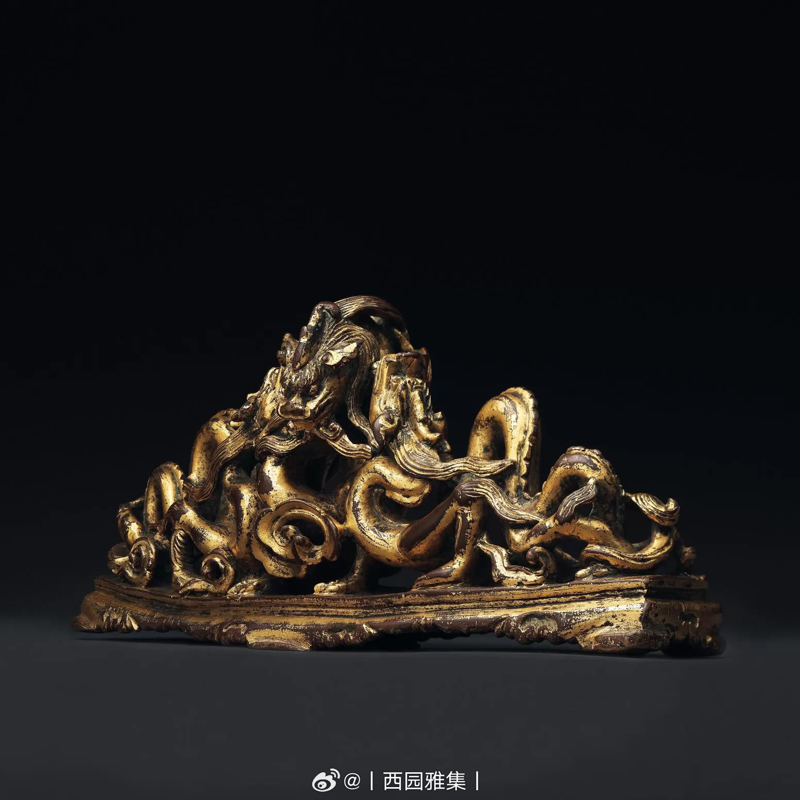 元至明初云龙鎏金笔格鎏金铜雕弧型笔格，作三金龙偏仰盘踞之状。三龙首及其身躯构成