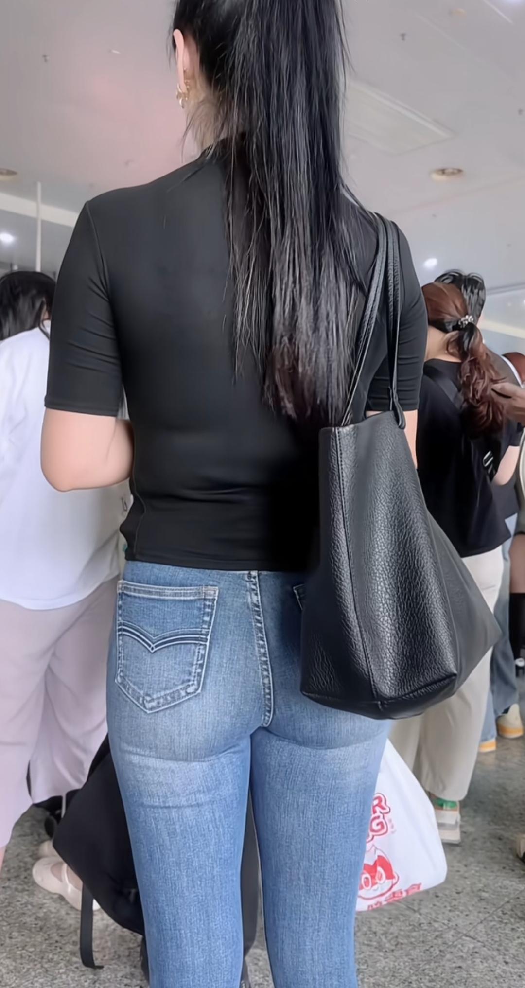长发姑娘背着包，正在排队。身高的女孩留这种马尾辫是最有气质的，还显身高，关键是精