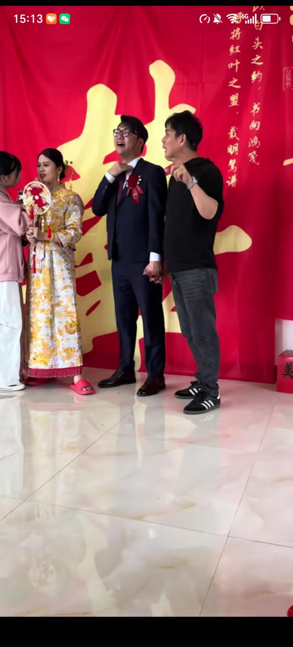 中式婚礼上，新娘抽空补妆，新郎悄悄和自己的伴郎十指相扣、不分彼此，一脸开心的样子