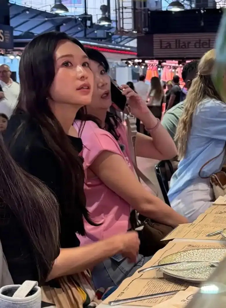 林志玲现身西班牙巴塞罗那逛集市，她身穿黑色露肩长款上衣搭配简约半身裤，这身穿搭时
