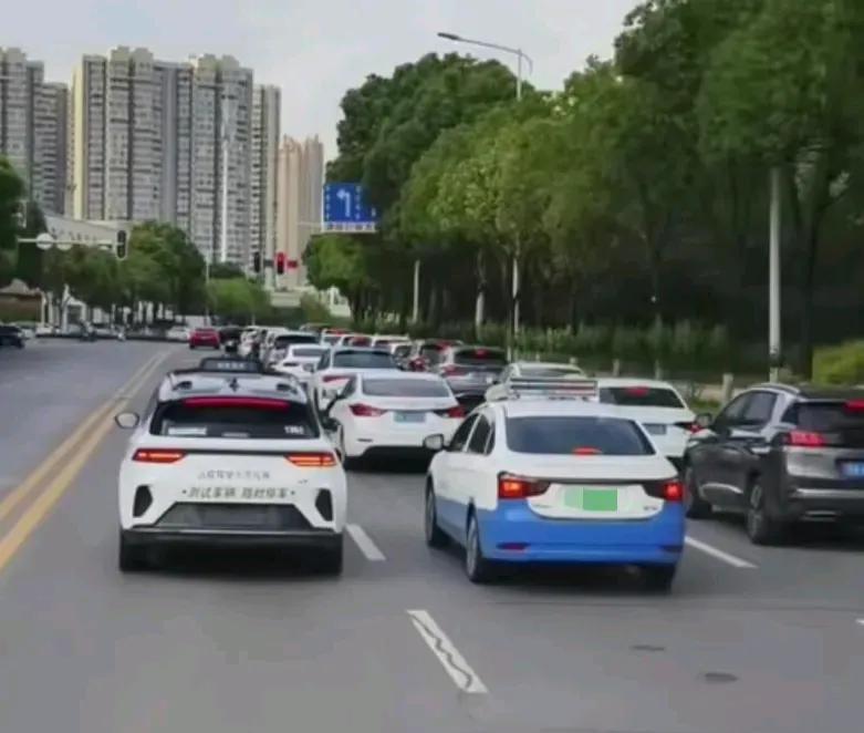 出租车围猎无人驾驶车，在无人驾驶车辆准备变道的时候，后面出租车不停地抢占位置，使