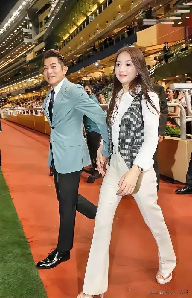 下面照片是天王郭富城与妻子的照片，看到郭富城穿着西服牵着妻子的手急匆匆的样子，这