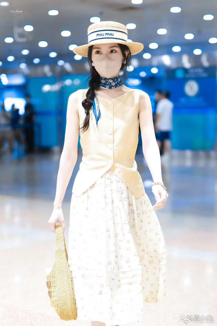 毛晓彤机场私服审美在线，亮黄马甲搭配碎花半裙，配色清新亮眼，穿搭时髦又有元气。