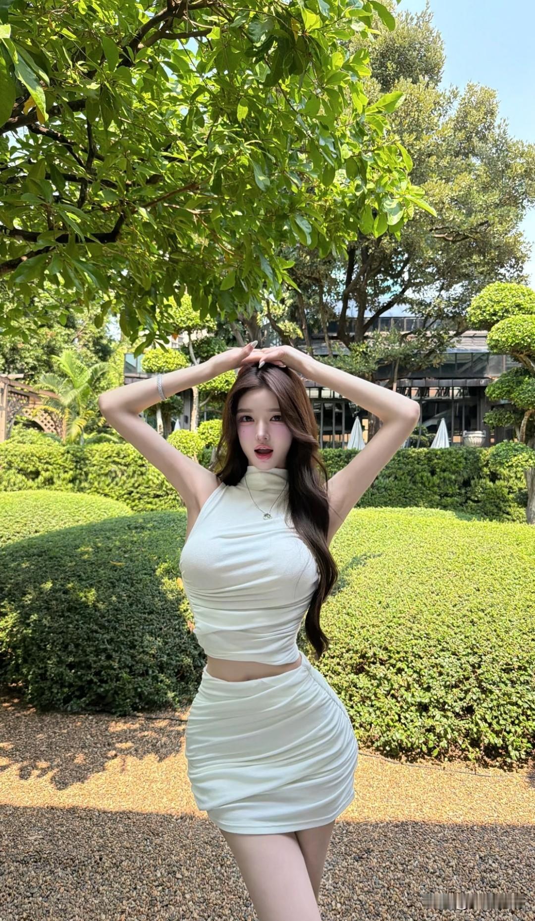 白色连衣裙在绿意盎然的背景下显得格外动人。