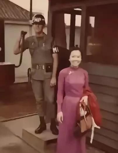 这是六十年代的西贡，一名越南女子下班后走出美军军营。这名越南女子年轻漂亮，身着越