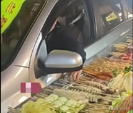 近日，贵州一男子开车回家经过小吃摊，卖烤串的小摊将小吃车摆到了将近路中间，竹签都