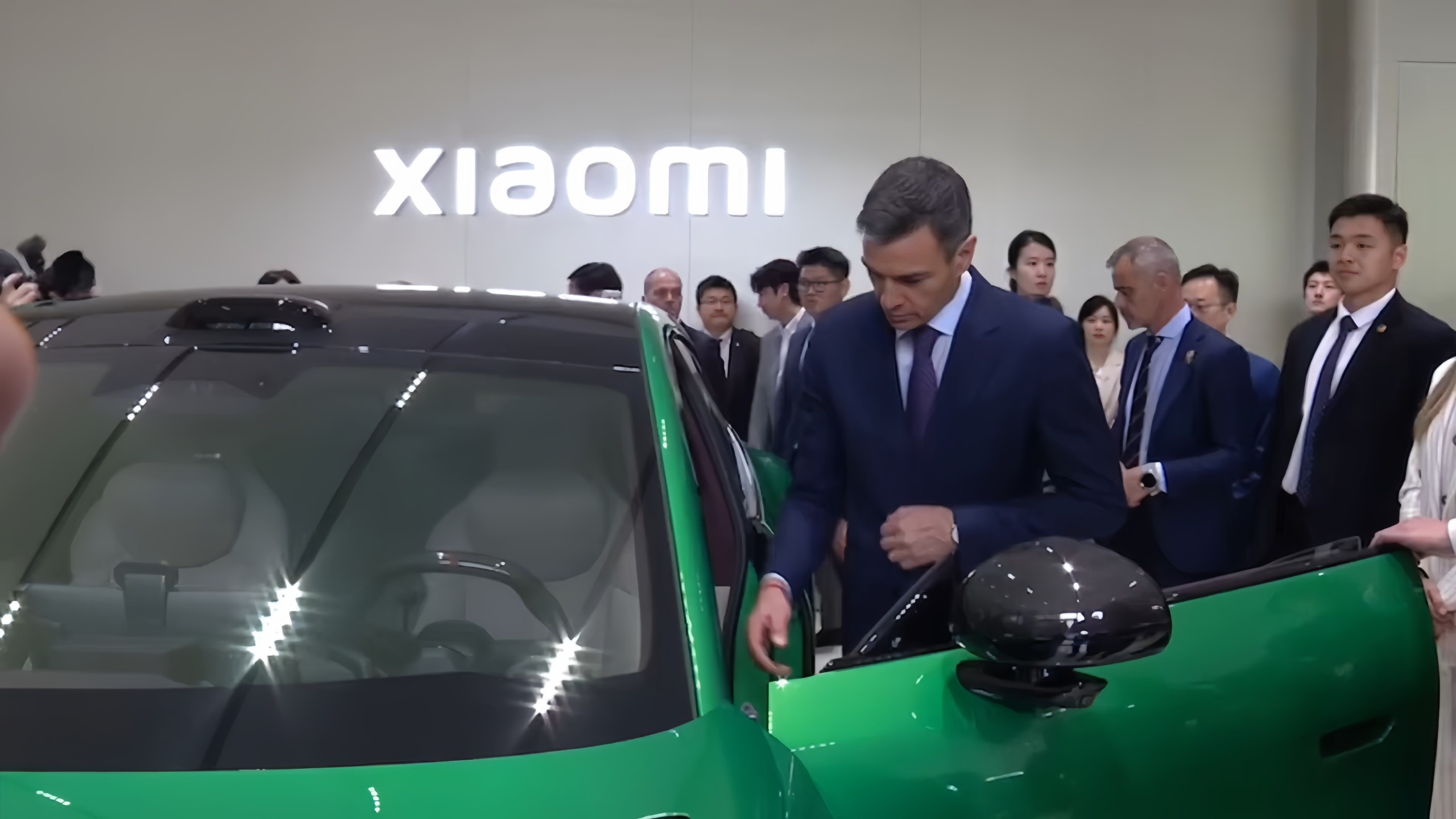 武契奇到小米汽车工厂参访图1图2是西班牙首相参观小米，本来人体型已经很大了，塞到