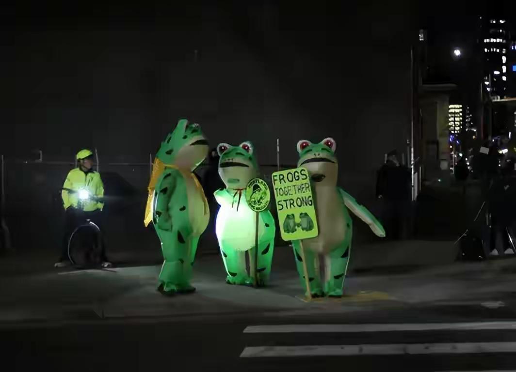 别笑美国街头的充气青蛙滑稽！这届抗议者玩的“幽默反杀”比喊口号、举标语高级不