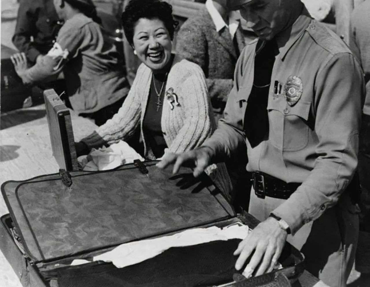 1942年4月，在加利福尼亚州洛杉矶的圣安妮塔集中营，一位日裔美国女士在一名官员