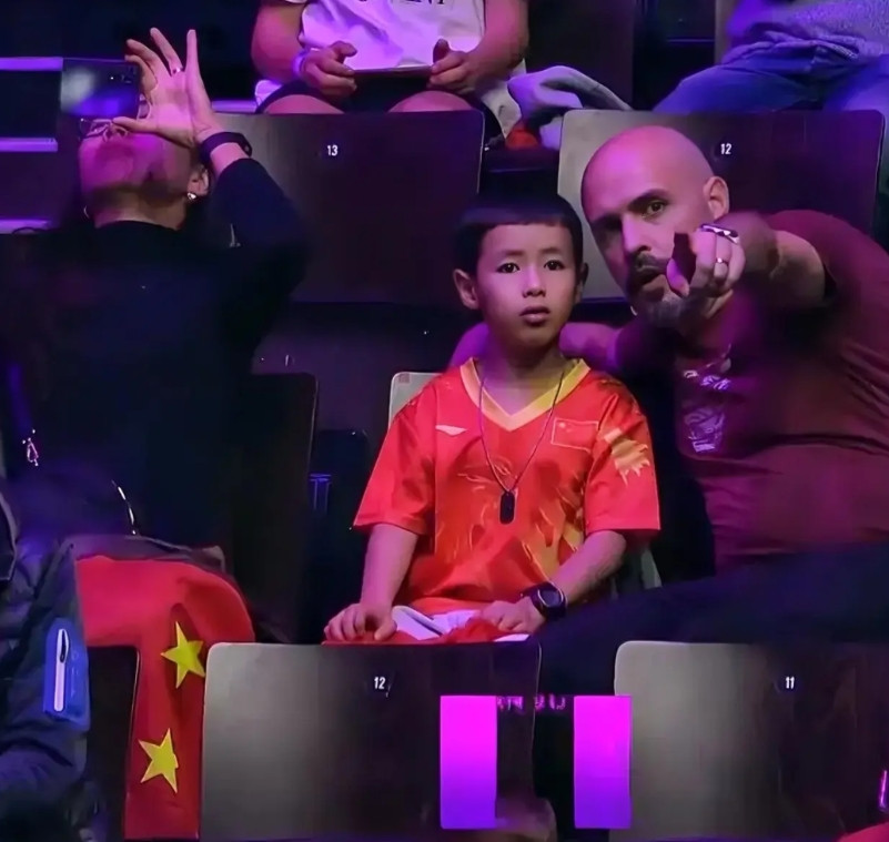 蒙彼利埃冠军赛，一位小朋友出现在观众席。手拿中国国旗。当旁边一位外籍男子手指镜